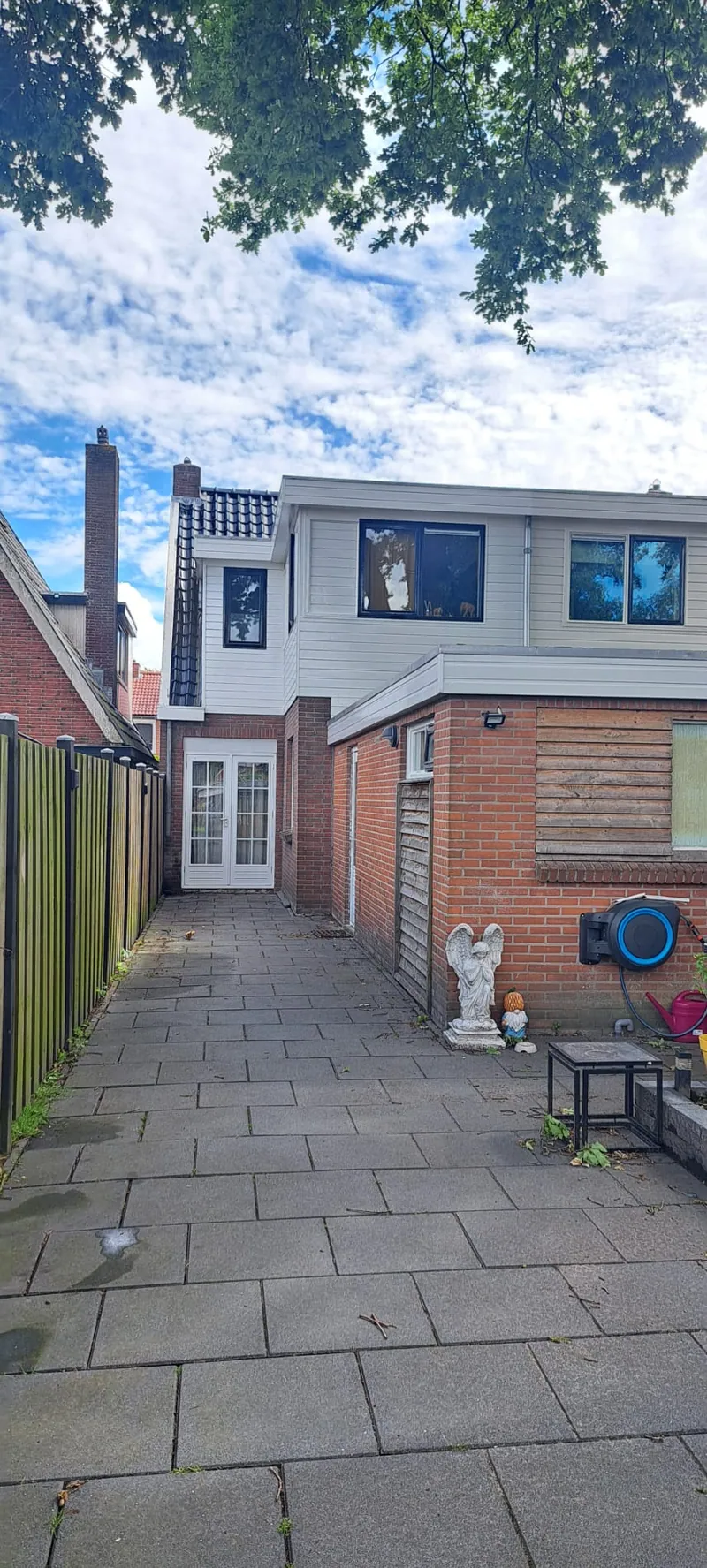 Dezelfde achtertuin na afloop: het schilderwerk is klaar en de steiger is weg.
