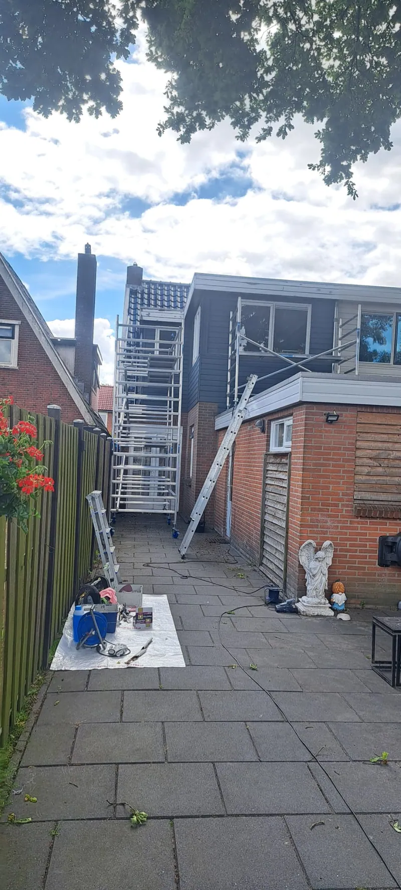 Achtertuin met dekzeil en steiger tijdens het schilderen van de aanbouw.