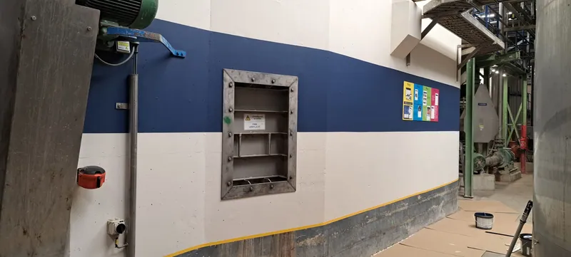 Blauw-witte hallenwand met een doorlopende gele bies.