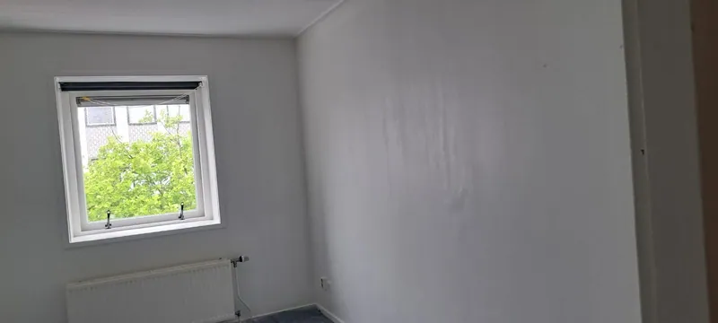 Kamer met witte muren en plafond na het schilderwerk.
