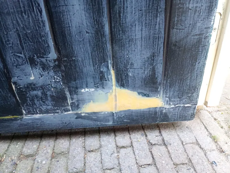 Zwarte houten gevel waar de rotte plek is uitgehaald en met plamuur is gevuld.