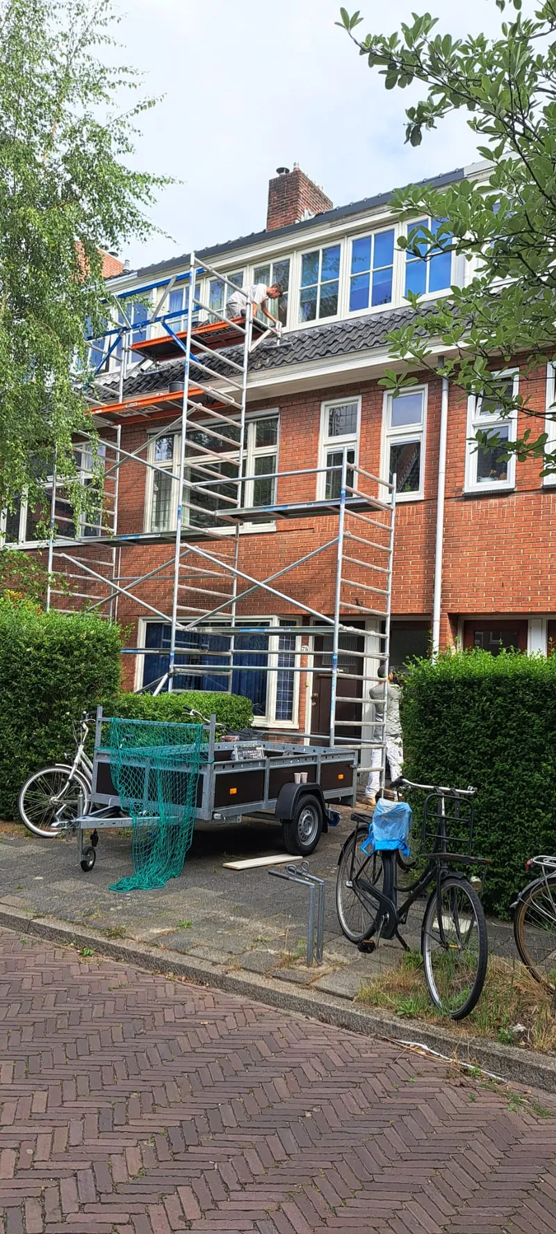 Rijtjeshuizen in de straat met de steiger over de gevels.