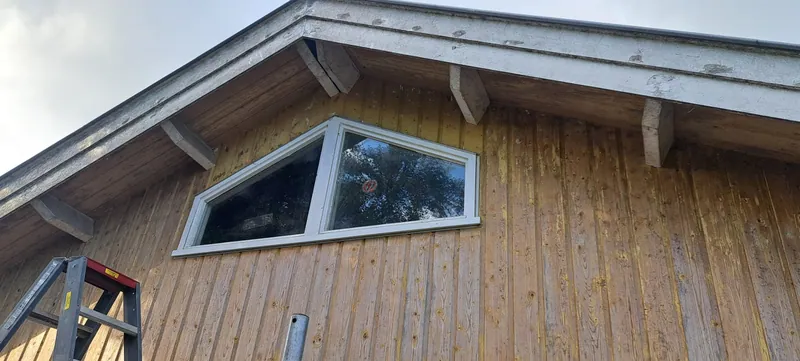 Houten topgevel met een wit kozijn en een wit boeiboord.