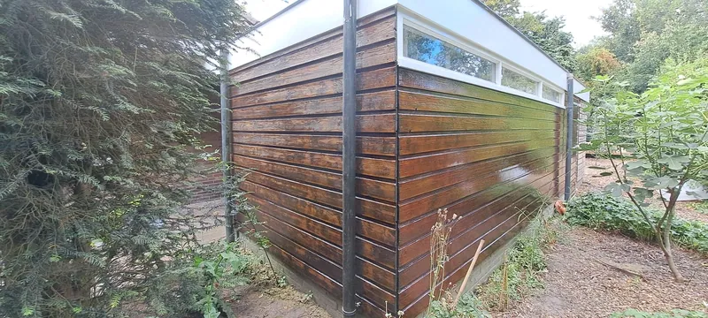 Houten veranda met glas, met de tuin ervoor.