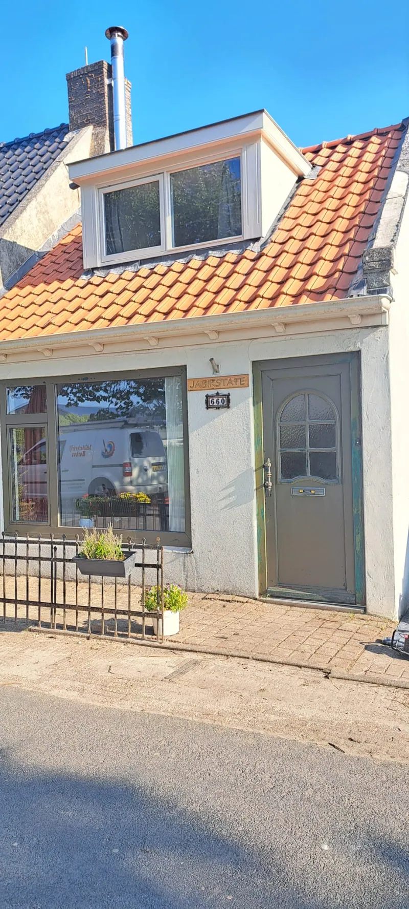 Dezelfde woning met een grijsgroene deur tijdens de werkzaamheden.